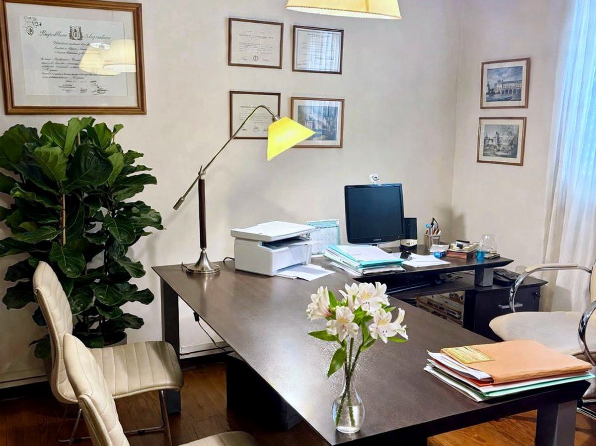 Despacho del Estudio Cetrángolo: escritorio de reuniones, sillas para las entrevistas y los títulos de la profesional enmarcados en la pared.